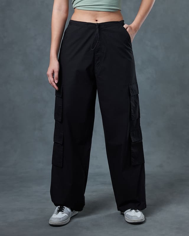 Close-up of the Bewakoof parachute pants front waist showing the high-rise slip-on waistband, black drawcord and slanted side pocket