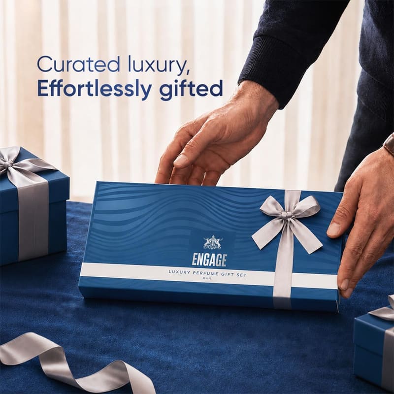 Hands presenting the wrapped navy Engage men's gift box, captioned Curated Luxury, Effortlessly Gifted