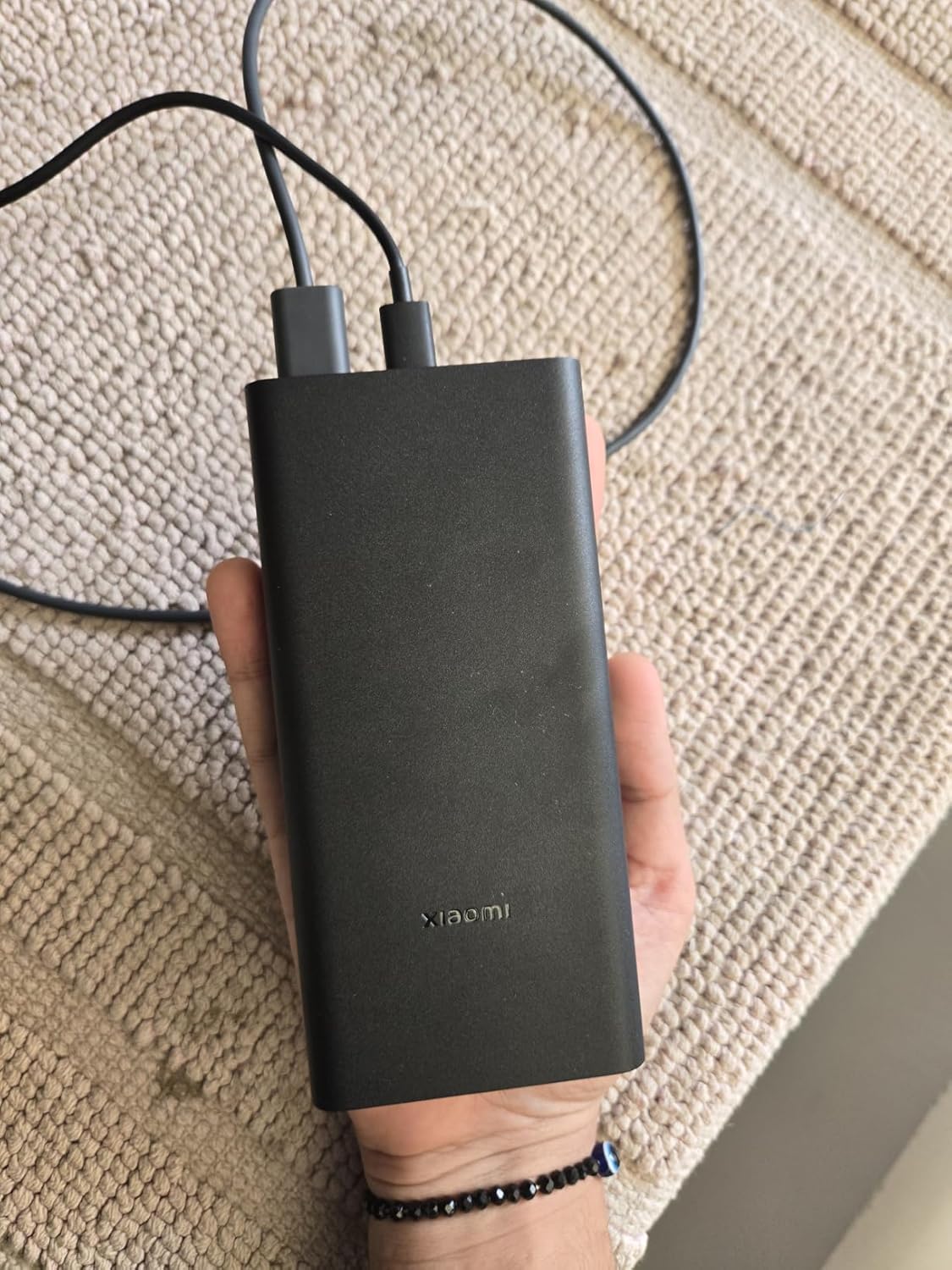 Xiaomi Power Bank 4i 20000mAh held in hand for scale, showing the triple output ports on the top edge